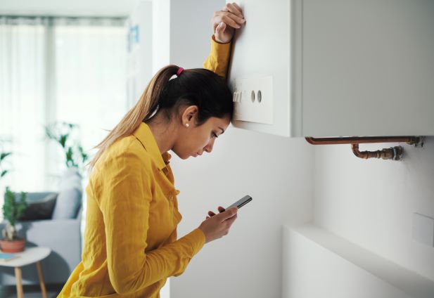 a woman about to call a 24 hour plumber